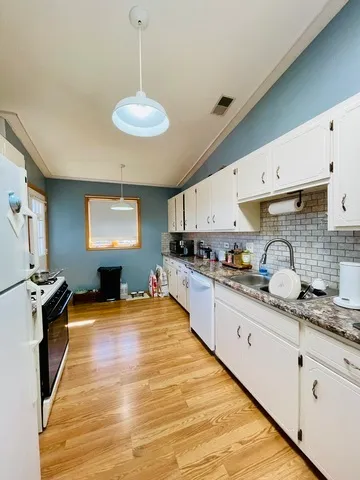 a kitchen with sink stove and refrigerator