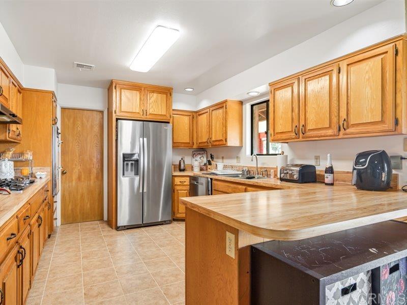 13913 Via De Jamul Jamul Ca Jamul, CA 91935 - Photo 16 of 67 a kitchen with stainless steel appliances granite countertop a refrigerator a stove and a sink with cabinets