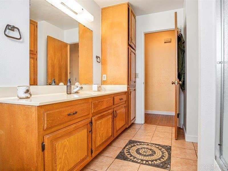 13913 Via De Jamul Jamul Ca Jamul, CA 91935 - Photo 28 of 67 a bathroom with a double vanity sink a mirror and a shower