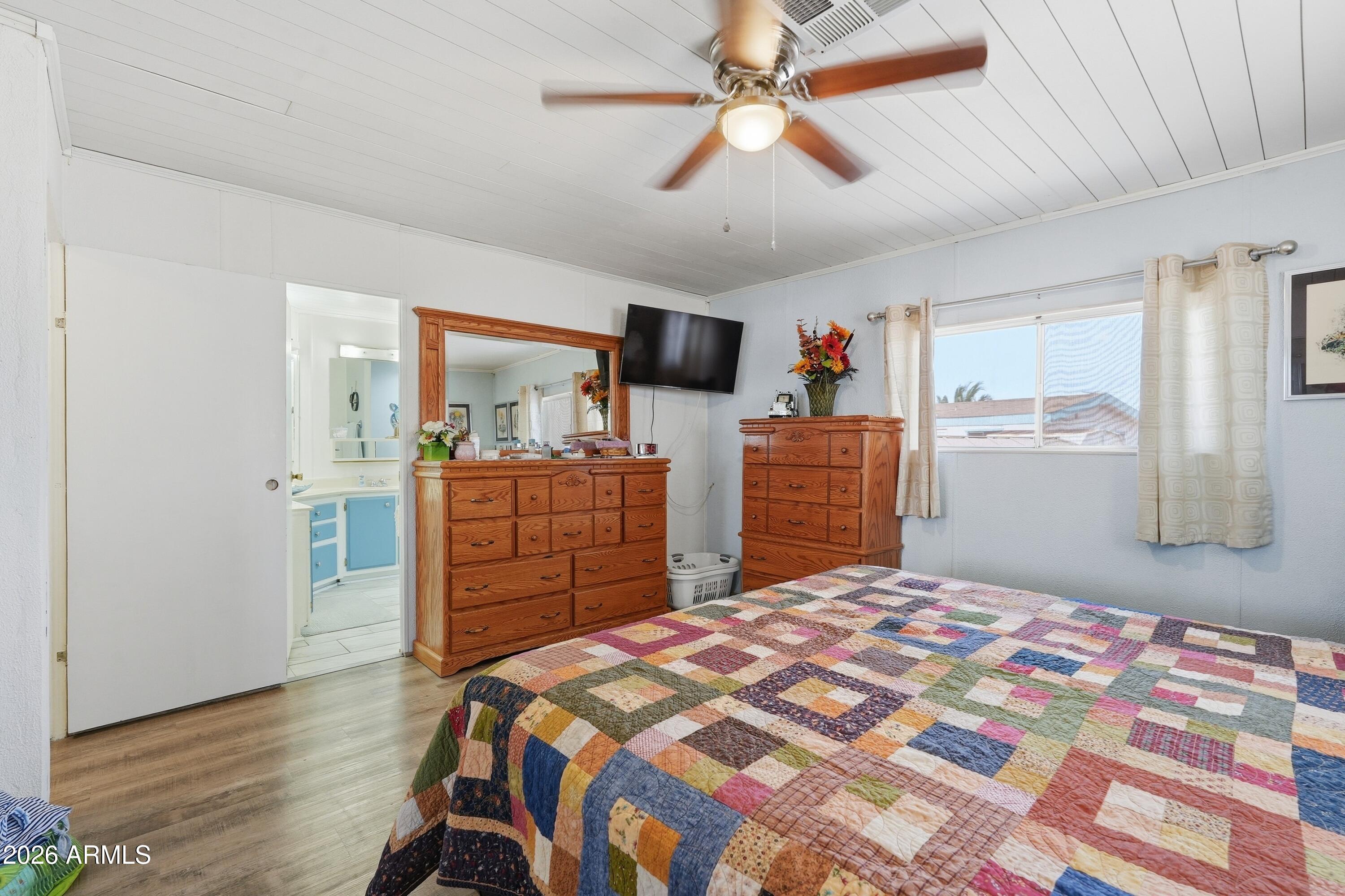 11100 West Alsdorf Road, Unit 50 Arizona City, AZ 85123 - Photo 18 of 36 a bedroom with a bed and wooden floor