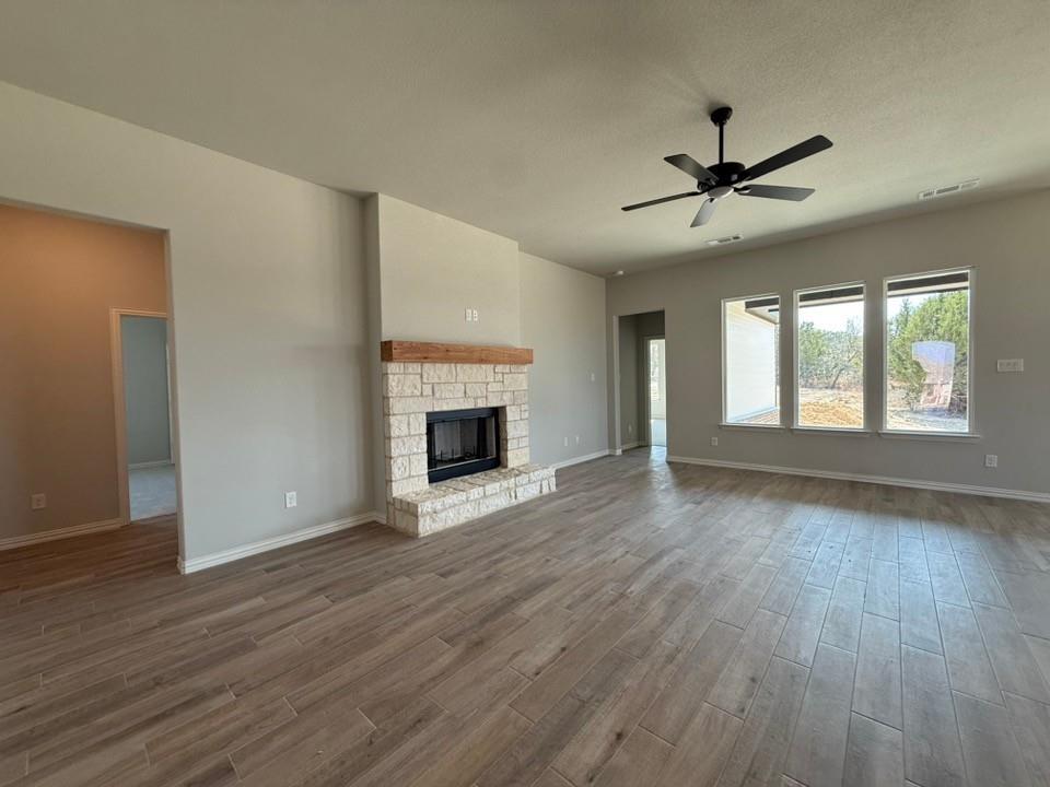 409 Hayden Faith Court Springtown, TX 76082 - Photo 11 of 23 a view of empty room with wooden floor and fireplace