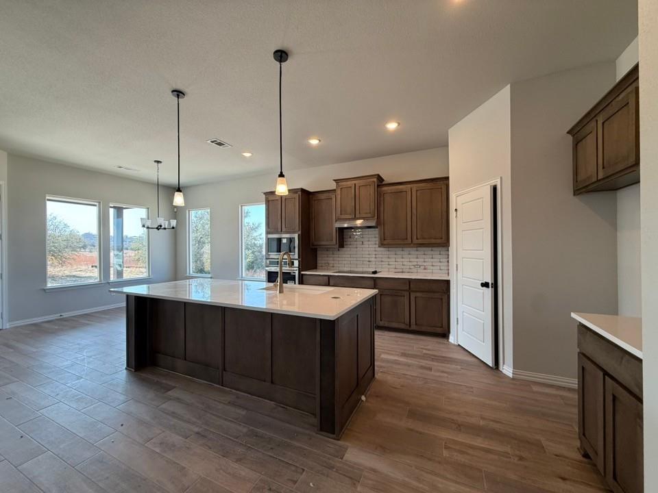 409 Hayden Faith Court Springtown, TX 76082 - Photo 13 of 23 a open kitchen with stainless steel appliances granite countertop a sink a stove and a wooden floor