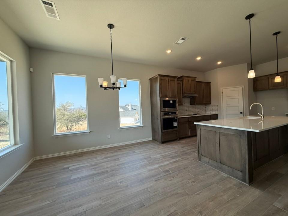 409 Hayden Faith Court Springtown, TX 76082 - Photo 15 of 23 a kitchen with stainless steel appliances granite countertop a sink a stove and a wooden floor
