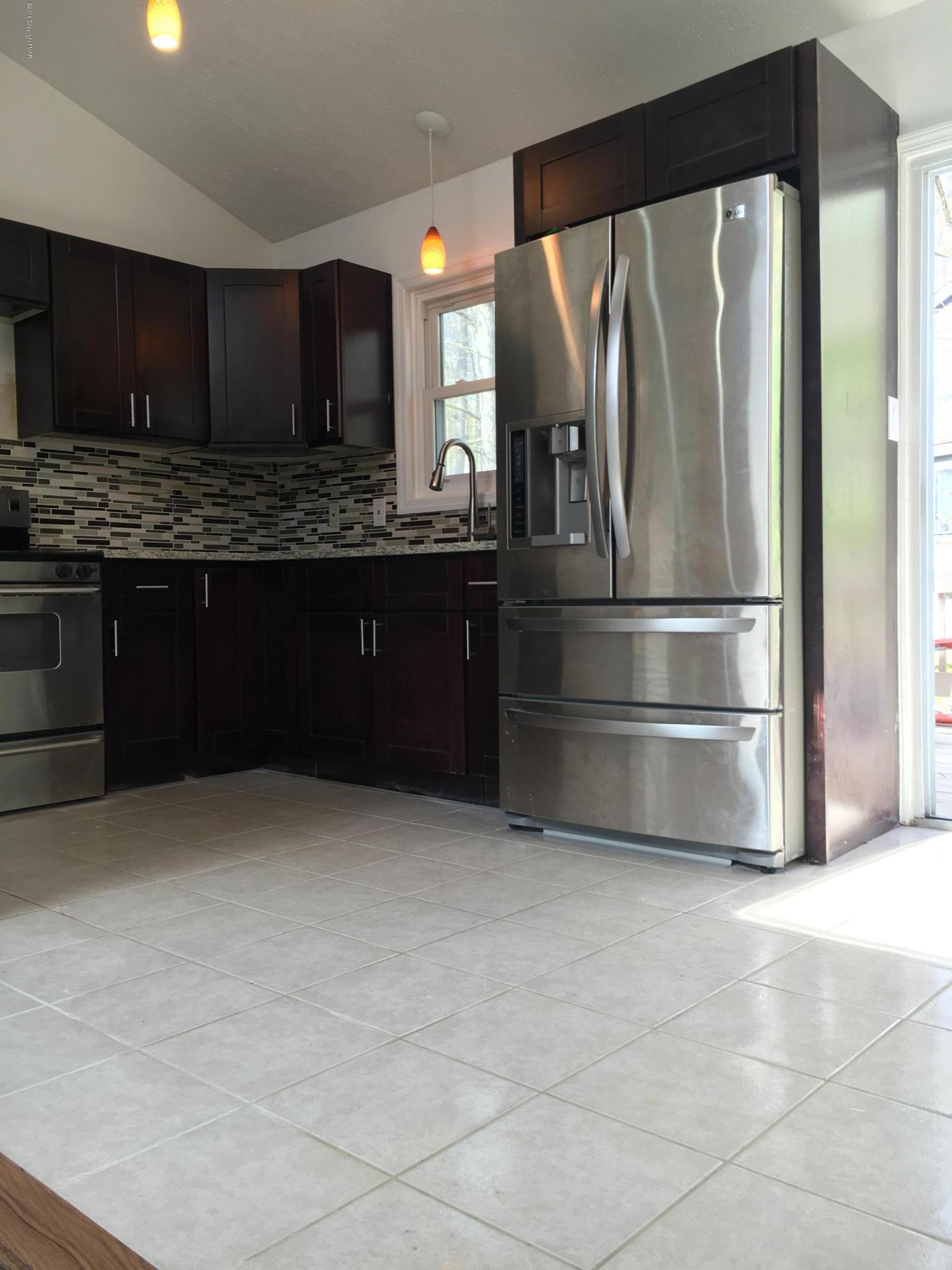 6229 Decker Road Bushkill, PA 18324 - Photo 4 of 15 a kitchen with granite countertop a refrigerator and a stove top oven