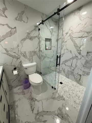 a bathroom with a toilet and a shower