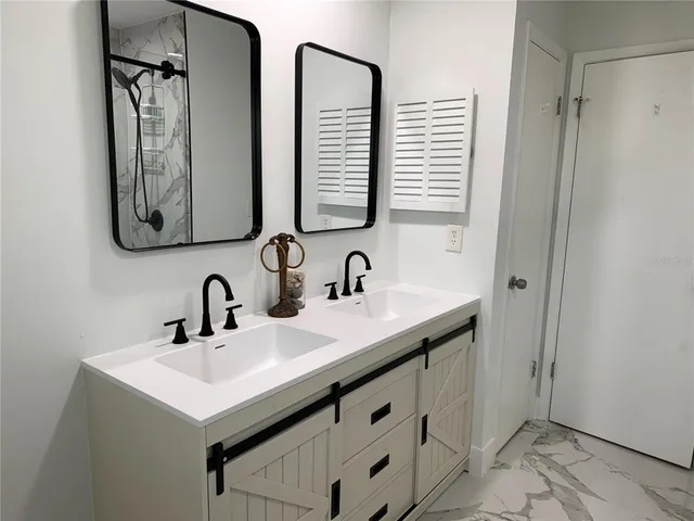 a bathroom with double vanity sink and a mirror