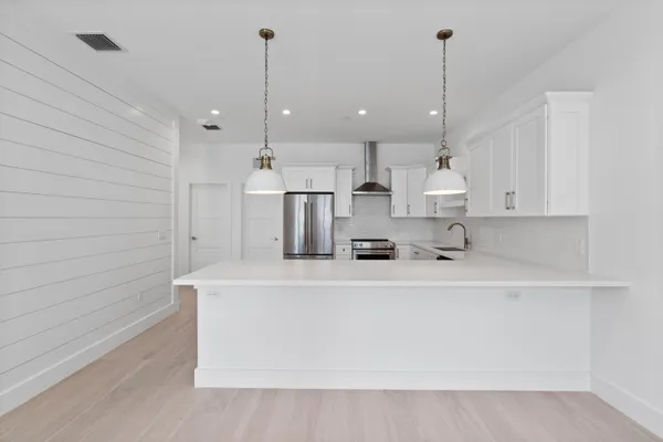 a view of kitchen with kitchen island and stainless steel appliances