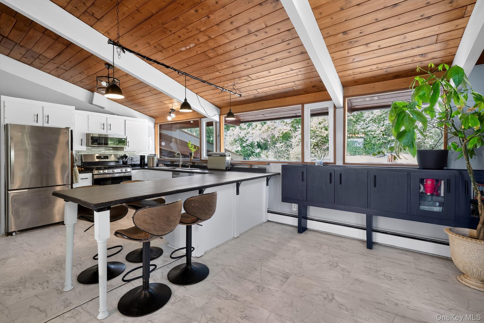 424 Laroe Road Chester, NY 10918 - Photo 30 of 43 Kitchen featuring a vaulted wood-paneled ceiling with exposed beams, white cabinetry, stainless steel appliances, and a large central island with seating