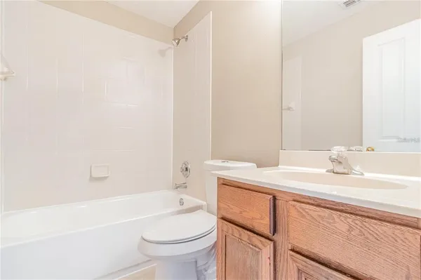 a bathroom with a sink toilet vanity and tub