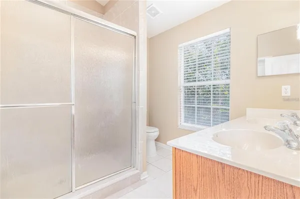 a bathroom with a granite countertop sink a toilet and shower