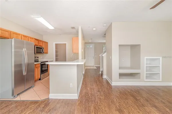 a kitchen with stainless steel appliances a refrigerator and wooden floor