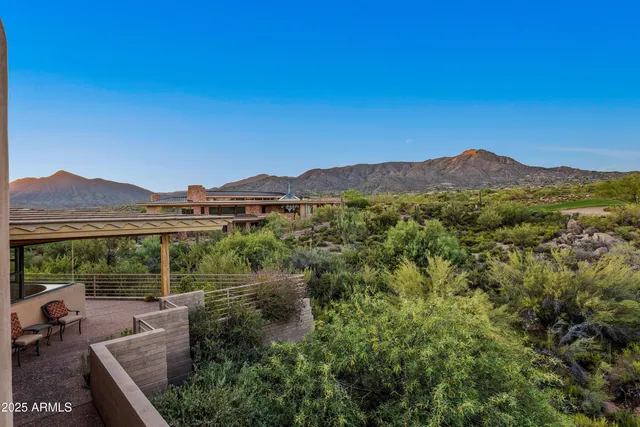 a view of a house with a yard and a large tree