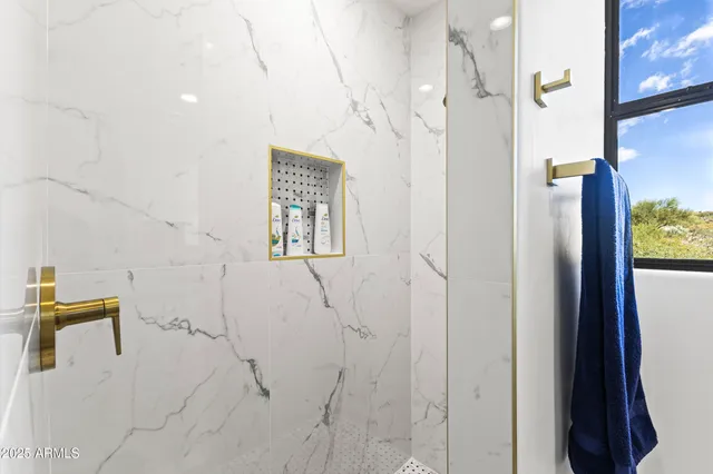 a bedroom with a bed and large windows