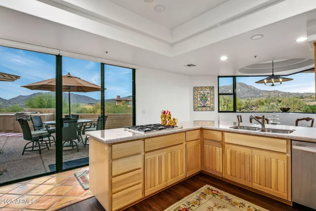 a kitchen with stainless steel appliances granite countertop a refrigerator a sink dishwasher a stove with white cabinets and wooden floor