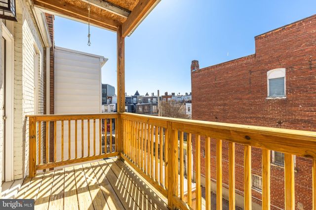 a view of a balcony with wooden floor and fence