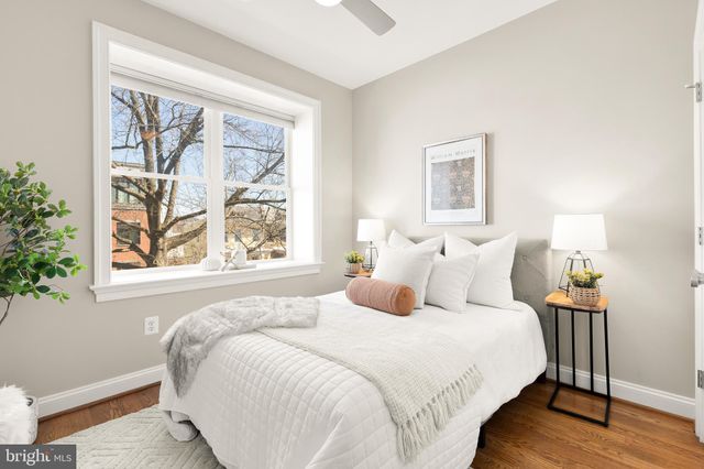 a bedroom with bed and a large window