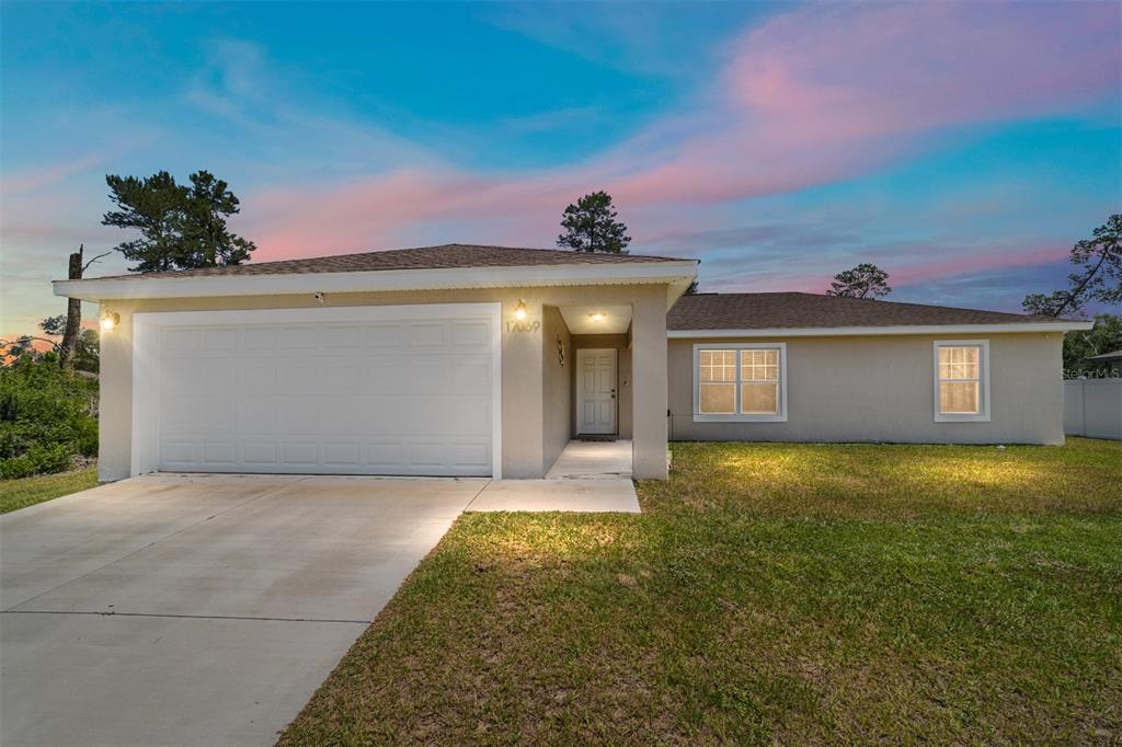 17069 Southwest 25th Terrace Road Ocala, FL 34473 - Photo 1 of 1 a front view of a house with a yard and garage