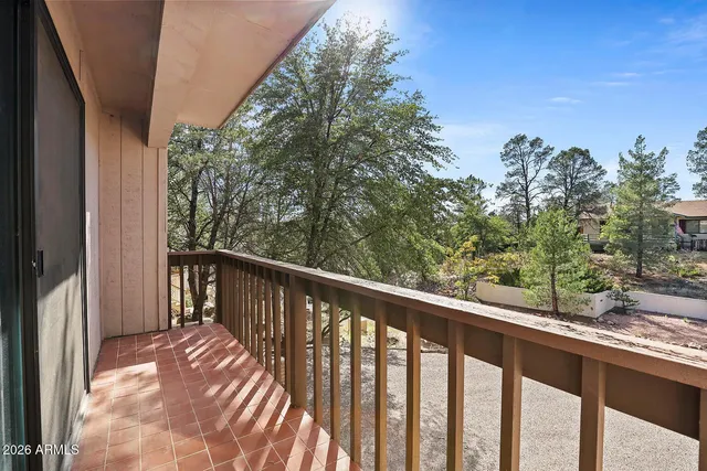 a view of balcony with wooden floor and fence
