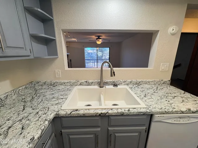 a kitchen with granite countertop a sink and a stove