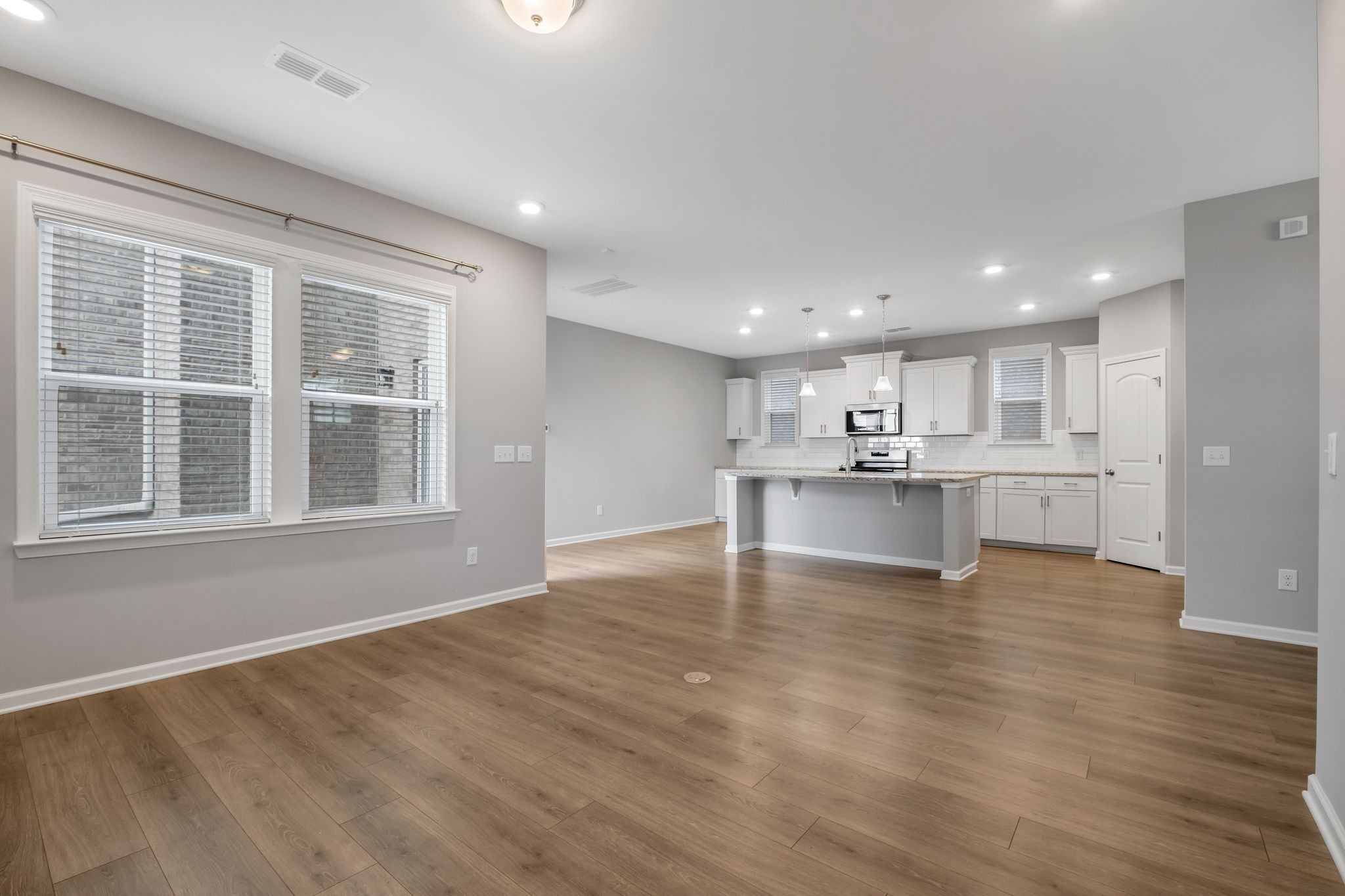 3721 Hoggett Ford Road Hermitage, TN 37076 - Photo 12 of 31 a view of an empty room with wooden floor and a kitchen