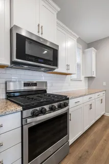 a kitchen with stainless steel appliances granite countertop a stove microwave and sink