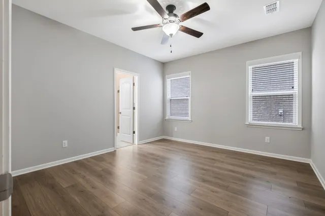 wooden floor in an empty room with a window