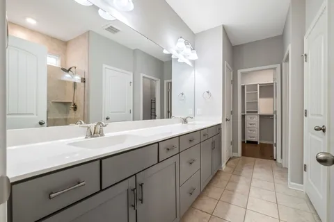 a spacious bathroom with a double vanity sink shower and a mirror