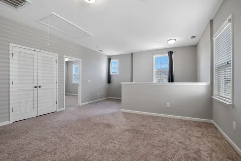 an empty room with windows and closet