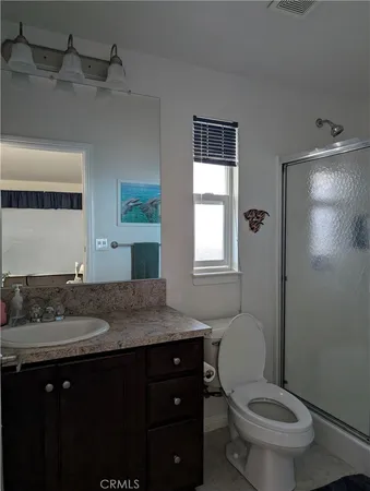 a bathroom with a granite countertop toilet sink and mirror