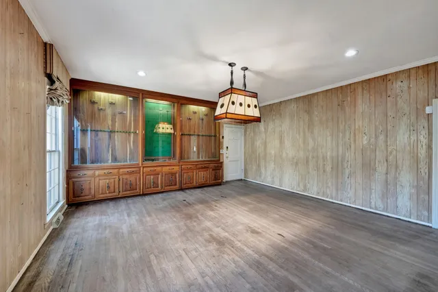 a view of an empty room with wooden floor and glass door