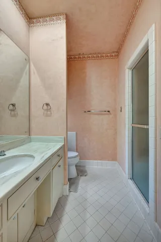 a bathroom with a granite countertop sink a toilet and a mirror