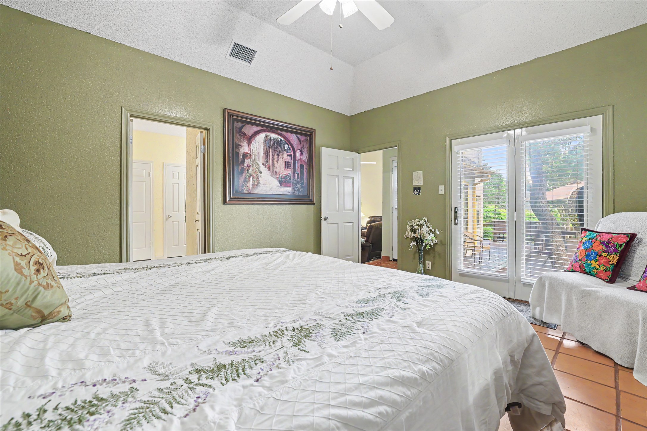 110 South Ridge Circle Georgetown, TX 78628 - Photo 16 of 37 Bedroom featuring a vaulted ceiling with a ceiling fan, terracotta-style tile flooring, and a double-door exterior entry with blinds