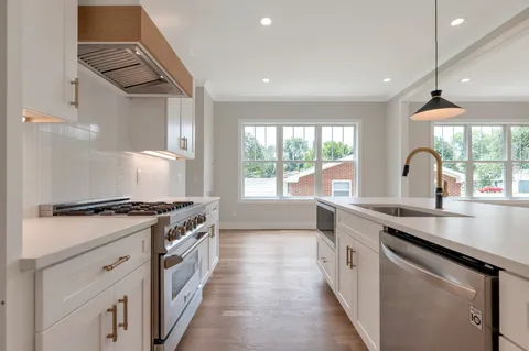 a bathroom with a toilet sink vanity granite and shower