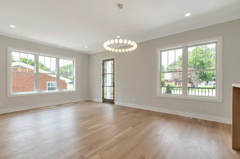 a kitchen with stainless steel appliances granite countertop a sink a refrigerator a stove a kitchen island with wooden floor and cabinets