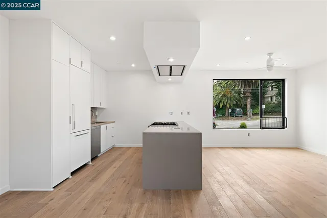 a kitchen with stainless steel appliances granite countertop a stove a refrigerator a sink a microwave oven with wooden floor and cabinets