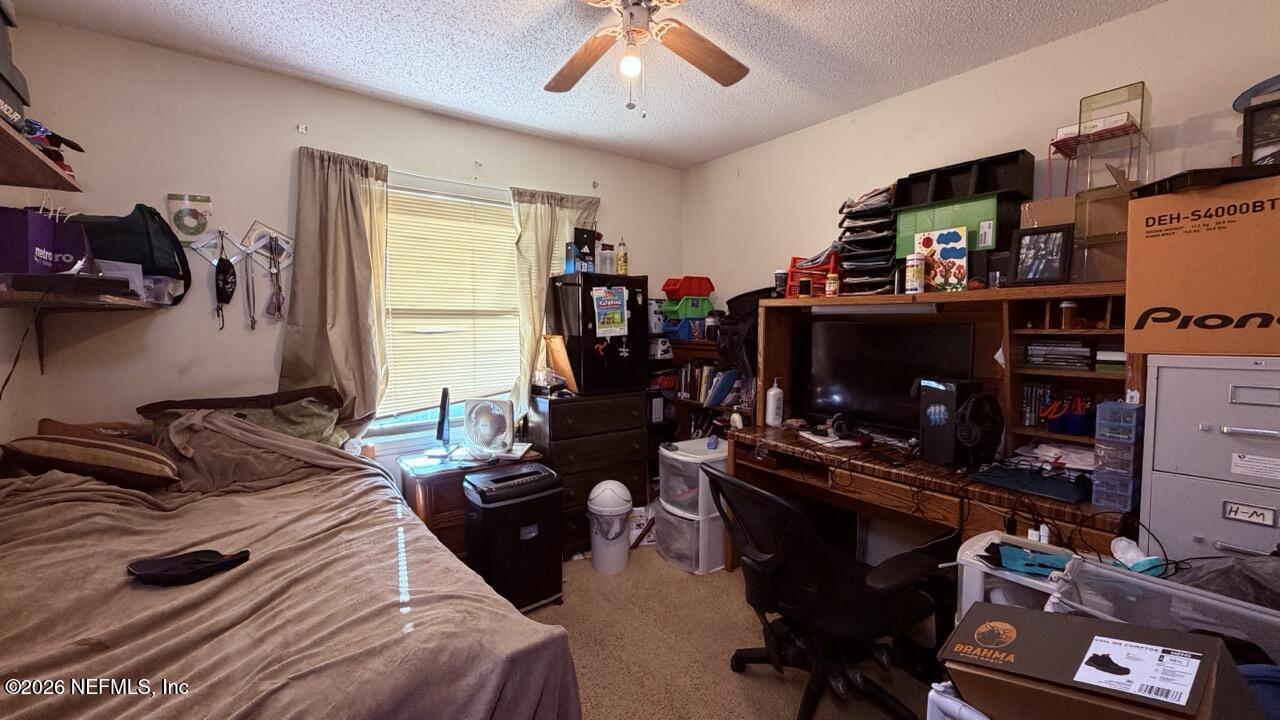 11432 Godfrey Way Jacksonville, FL 32223 - Photo 6 of 18 a bedroom with a bed and a flat tv screen