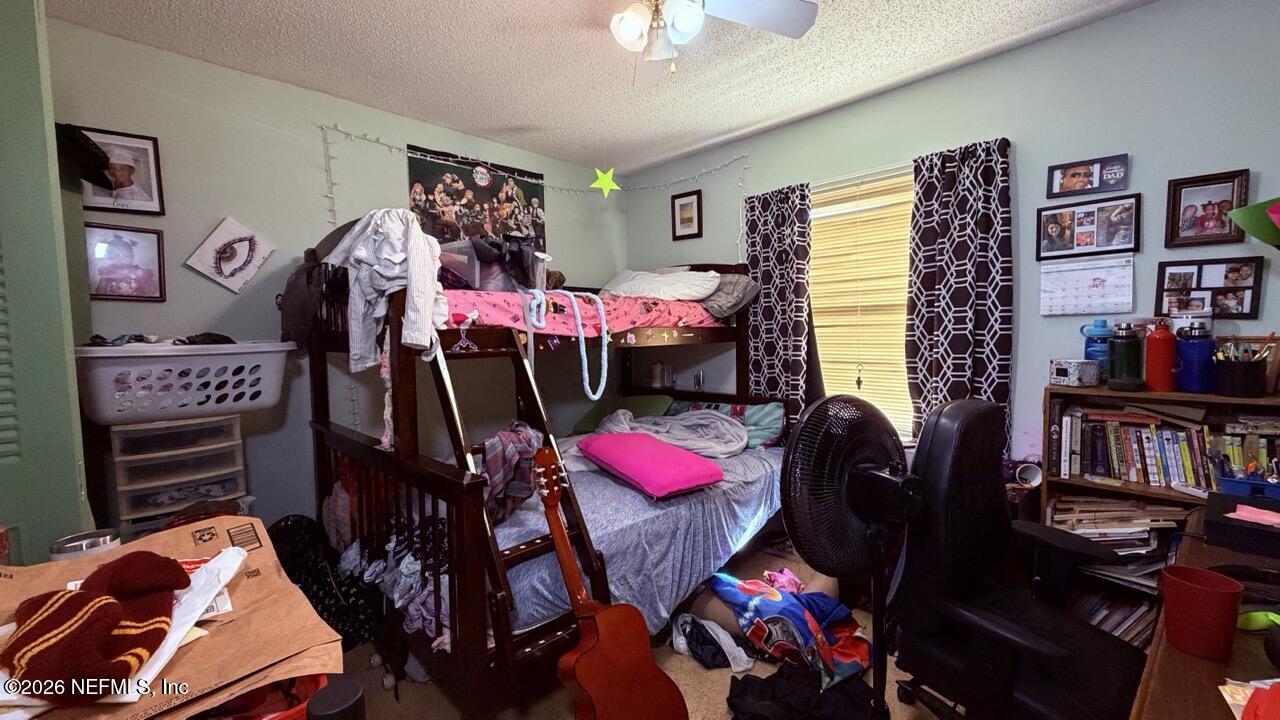 11432 Godfrey Way Jacksonville, FL 32223 - Photo 7 of 18 a bedroom with furniture and a book shelf