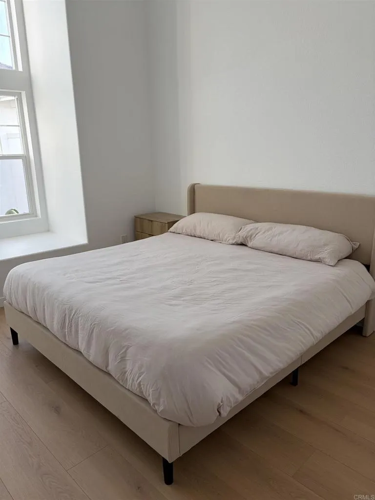 815 Harbor Cliff Way, Unit 239 Oceanside, NY 11572 - Photo 6 of 11 a bedroom with a bed and a window