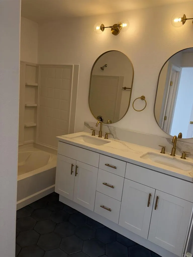 815 Harbor Cliff Way, Unit 239 Oceanside, NY 11572 - Photo 7 of 11 a bathroom with a double vanity sink and a mirror