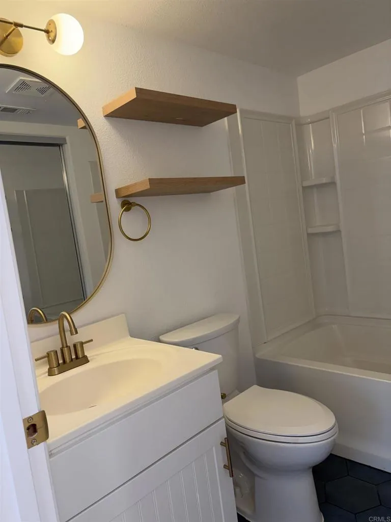 815 Harbor Cliff Way, Unit 239 Oceanside, NY 11572 - Photo 8 of 11 a bathroom with a sink a toilet and shower