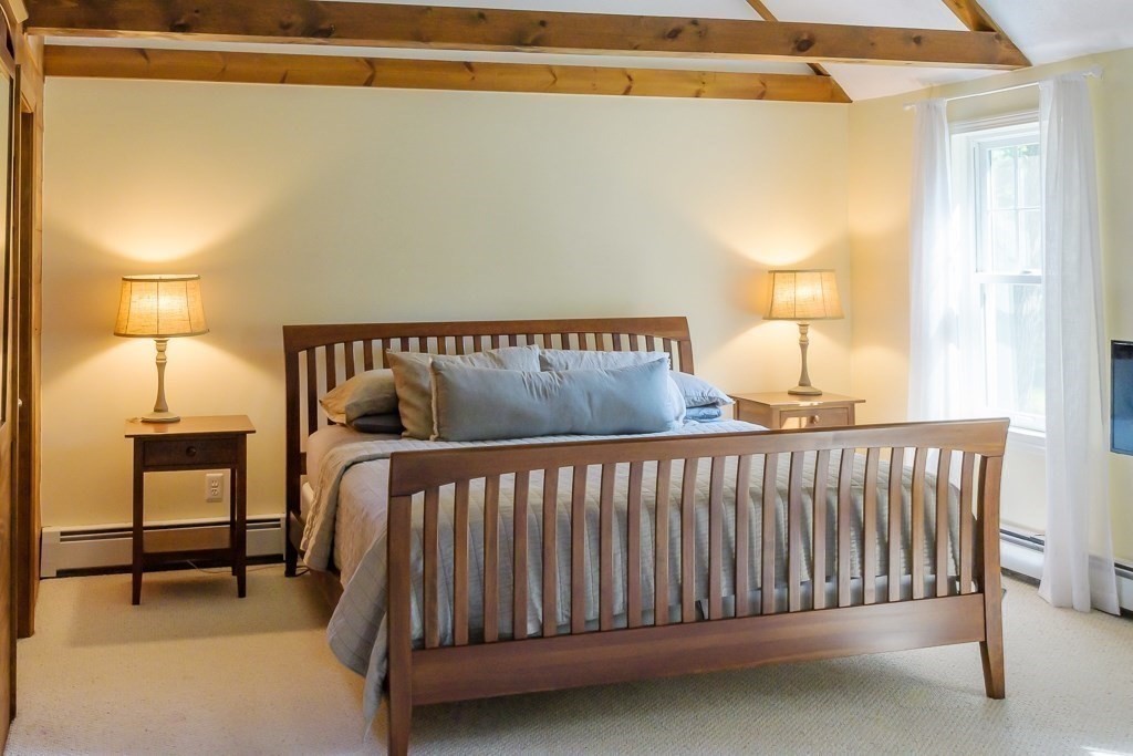 183 Littleton Road Harvard, MA 01451 - Photo 11 of 30 a bed sitting in a bedroom next to a lamp