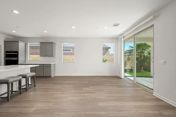 a view of an empty room with glass door and windows