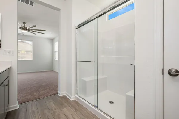 an empty room with a window and a fan