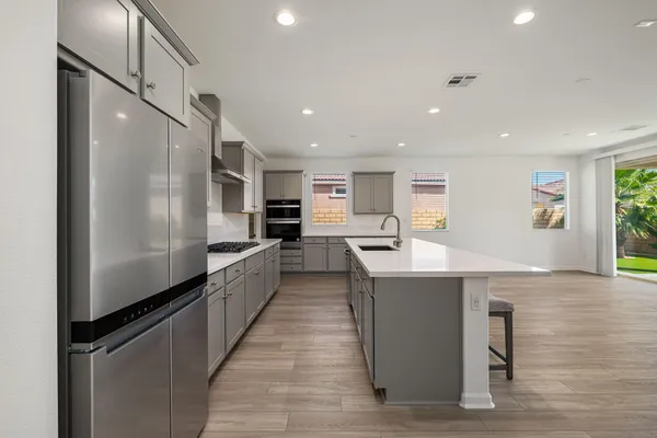 a large kitchen with stainless steel appliances granite countertop a large counter top a stove and a sink