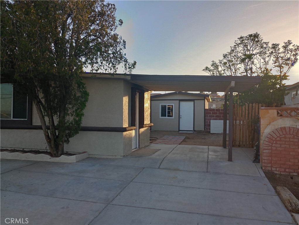 1426 Riverside Drive Barstow, CA 92311 - Photo 15 of 19 a backyard of a house with large trees and outdoor seating