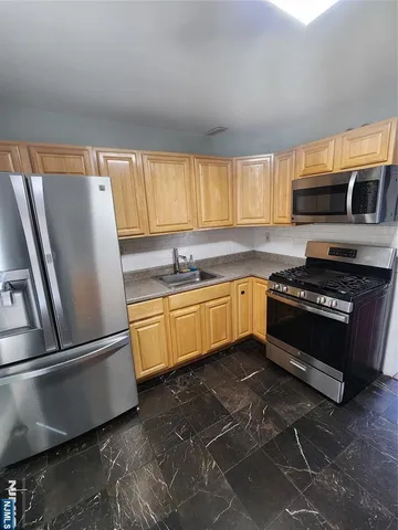 a kitchen with granite countertop a sink stainless steel appliances and cabinets