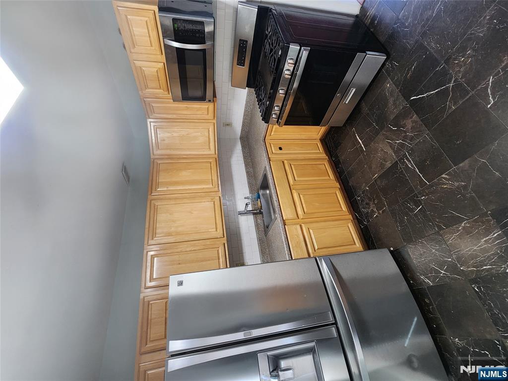 30 West 15th Street, Unit 2 Linden, NJ 07036 - Photo 3 of 7 a kitchen with granite countertop a sink stainless steel appliances and cabinets