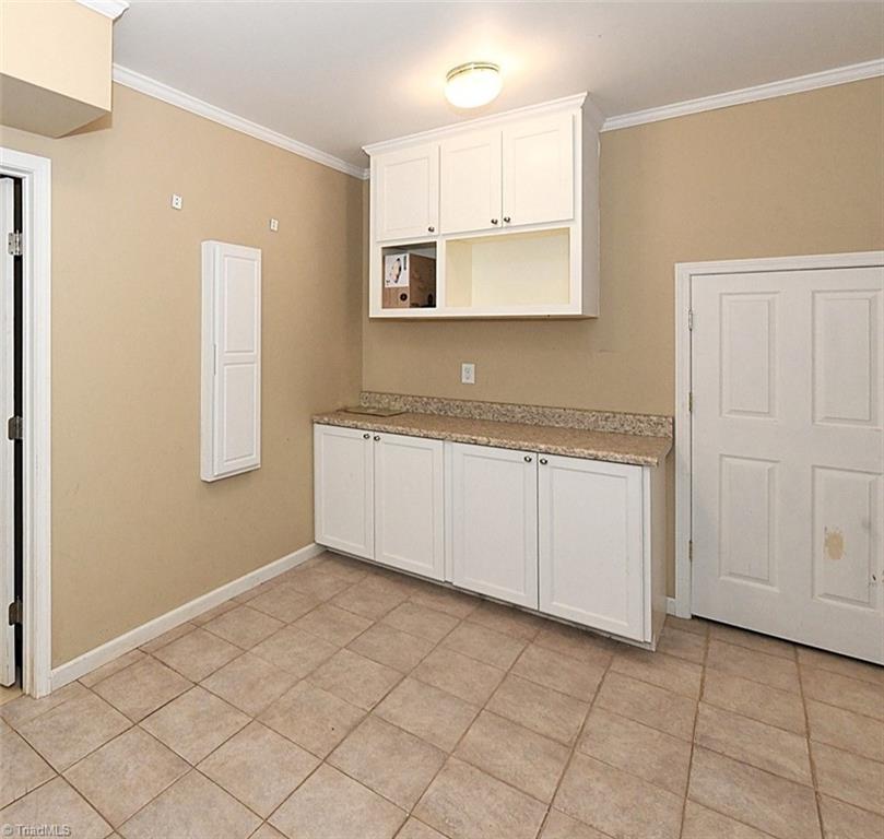 128 Lynne Avenue King, NC 27021 - Photo 20 of 27 Laundry Room - Built-in Ironing Board and Tile Floors. Convenient Understair Storage