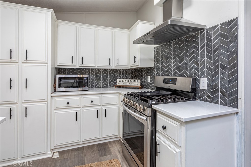 27568 Ruby Lane Castaic, CA 91384 - Photo 11 of 34 a kitchen with cabinets appliances and a wooden floor