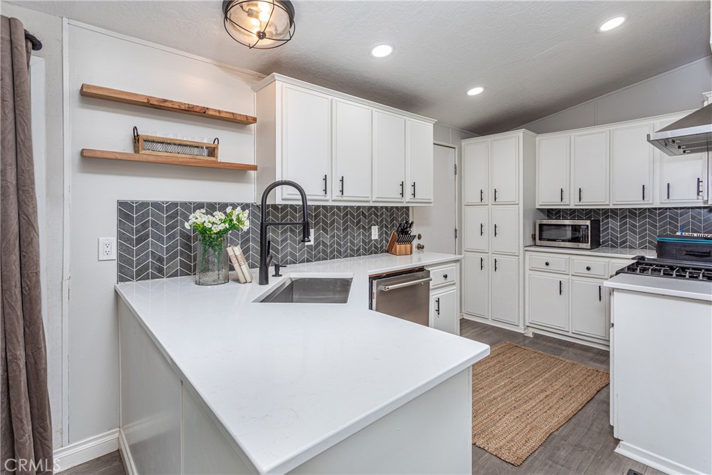 27568 Ruby Lane Castaic, CA 91384 - Photo 13 of 34 a kitchen with stainless steel appliances a white stove top oven sink and cabinets